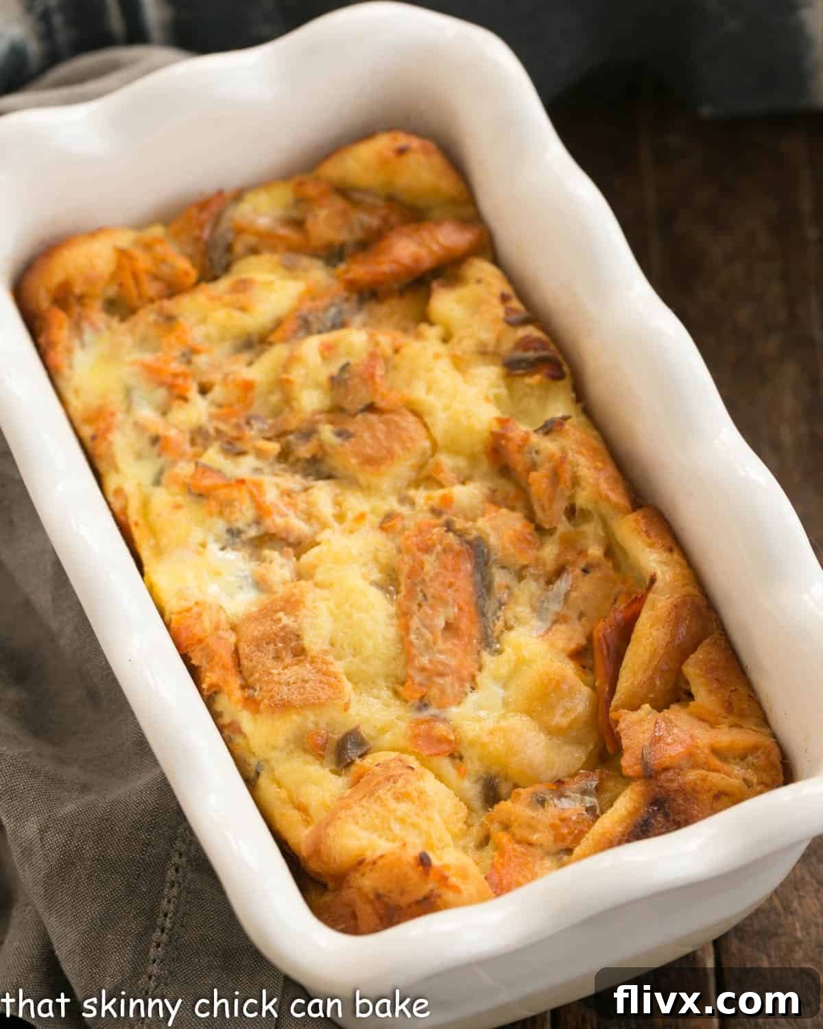 An inviting overhead view of a golden-brown salmon loaf, perfectly baked and nestled in a rustic ceramic loaf pan, ready to be sliced and served.