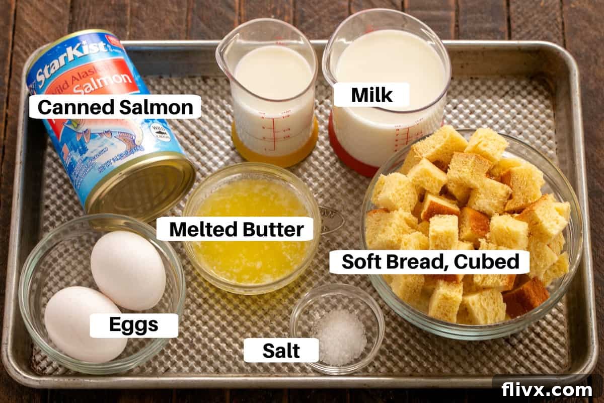 All the essential Salmon Loaf Ingredients neatly arranged with labels on a sleek metal sheet pan, showcasing the simplicity and freshness.