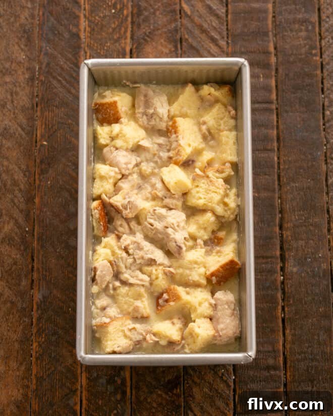 Step 4: The salmon loaf mixture being carefully placed into a greased loaf pan, ready for baking.