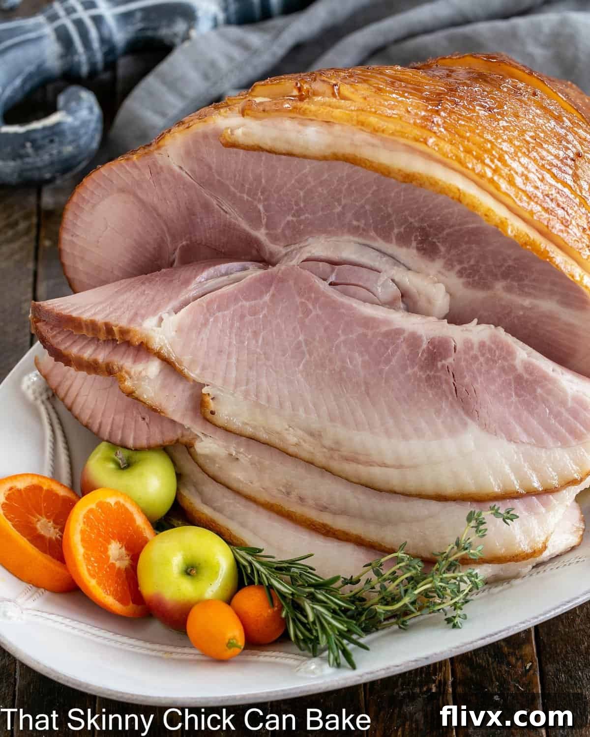 Honey Mustard Glazed ham on a white platter with fruit garnishes.