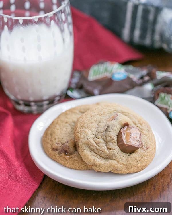 Two Milky Way Cookies chunks of Milky Way on a small white plate with a glass of milk.