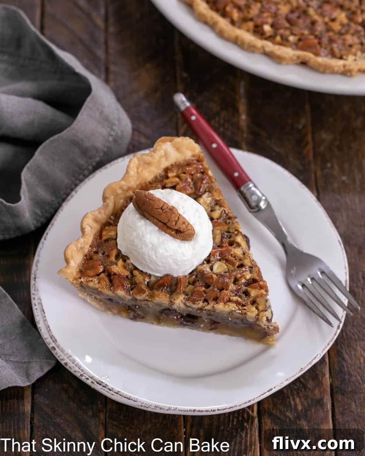 Overhead view of a slice of Derby Pie topped with whipped cream and a pecan on a white dessert plate