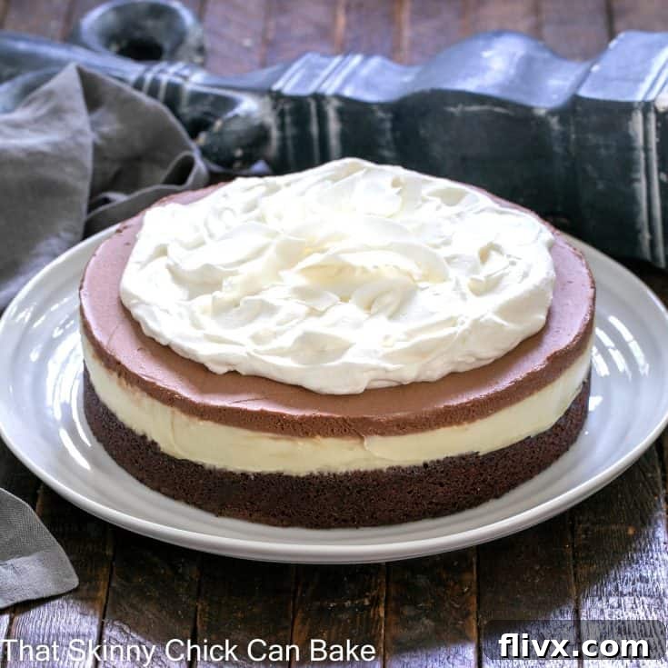 A perfectly layered Coconut Brownie Cake slice on a white ceramic plate, ready to be enjoyed.