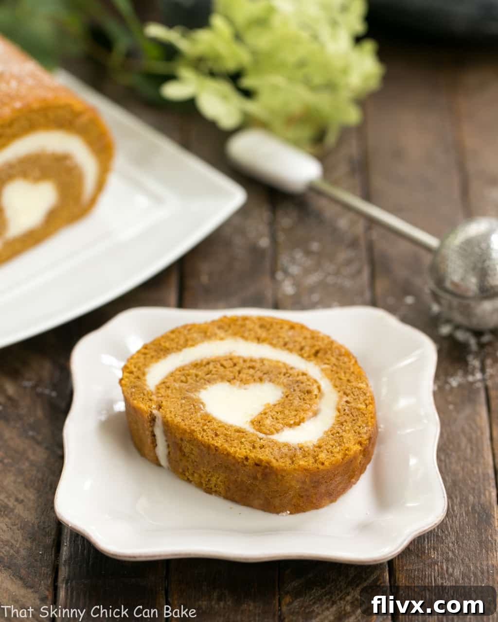 A delectable slice of Old Fashioned Pumpkin Roll on a square ceramic dish, showcasing the beautiful spiral of pumpkin cake and rich cream cheese filling.