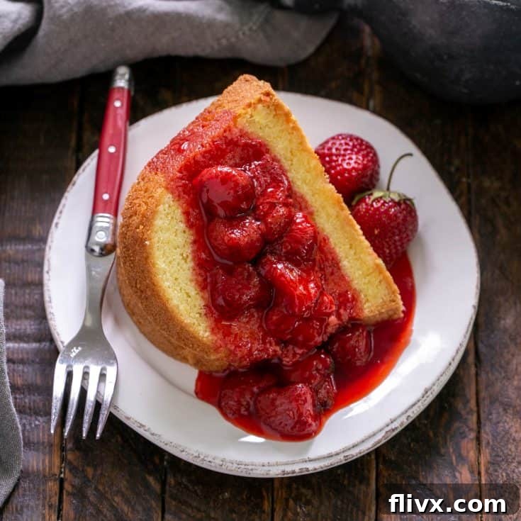 Strawberry compote over a slice of pound cake on a white dessert plate