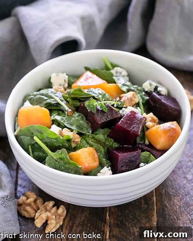 A vibrant peach and beet salad served in a elegant white salad bowl, showcasing a colorful and healthy dish.