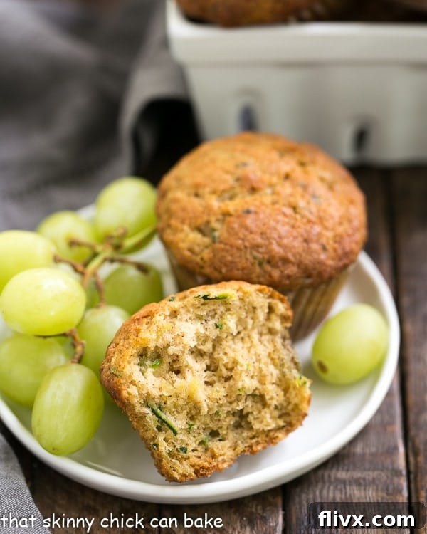Cinnamon Zucchini Muffins on a small white plate with green grapes, inviting and delicious looking.