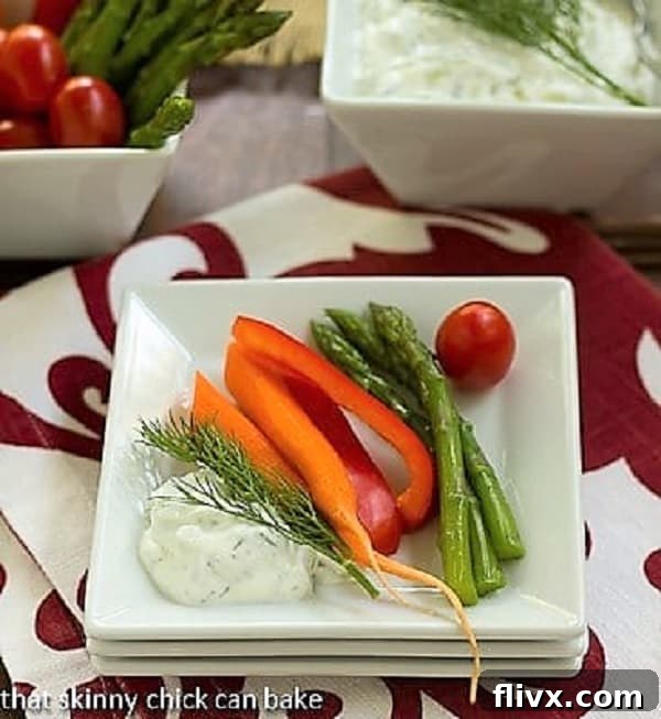 Tzatziki Dip - a refreshing and versatile Greek yogurt sauce featuring fresh herbs, fragrant garlic, and crunchy cucumber, ideal for pairing with crudites or grilled dishes. A vibrant display of freshly made Tzatziki Dip elegantly arranged on a stack of pristine white plates, surrounded by a colorful assortment of crisp, garden-fresh vegetables like cucumber slices, carrot sticks, cherry tomatoes, and bell pepper strips, perfect for healthy dipping.