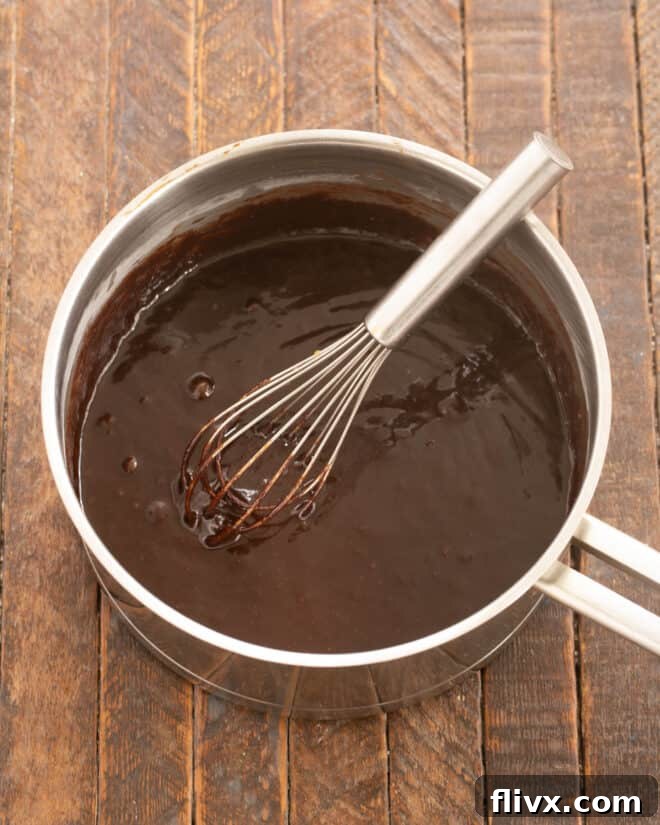 Salt, vanilla and eggs are whisked into the melted butter and cocoa mixture, then flour is stirred in.