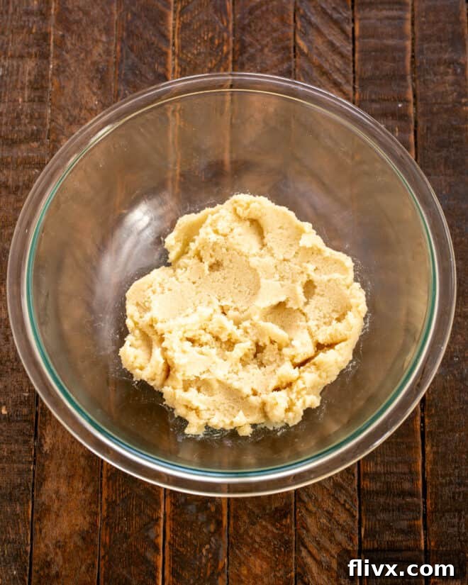 Butter and sugars mixed together in a bowl for the cookie dough layer.