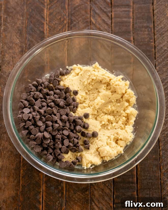 Dry ingredients mixed into cookie dough, followed by chocolate chips.