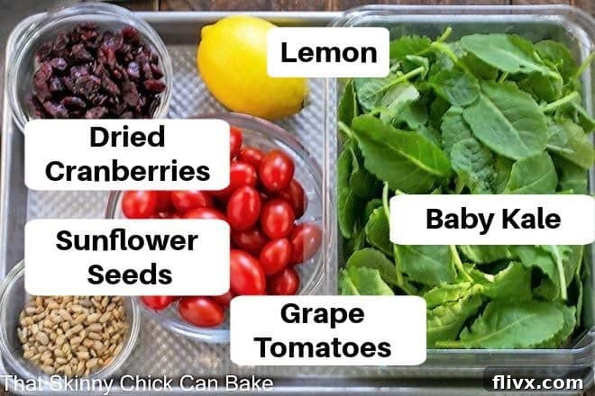 Overhead view of labeled kale salad ingredients on a sheetpan.