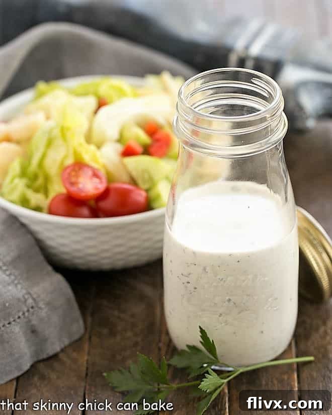 Best Ranch Dressing Recipe - Discover how to make ranch dressing with fresh herbs for the perfect salad topping. A glass jar filled with the ultimate homemade ranch dressing, showcasing its creamy texture and fresh herb flecks.