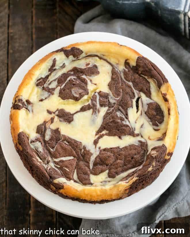 Overhead view of a beautifully Marbled Flourless Chocolate Cake on a white cake stand, showcasing the intricate chocolate and vanilla swirls perfect for any celebration.