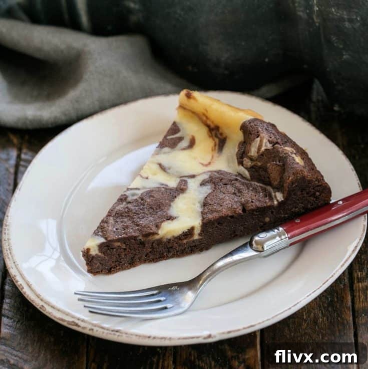 A slice of Marbled Flourless Chocolate Cake on a white dessert plate, with a red fork ready to enjoy the rich chocolate and creamy vanilla layers.