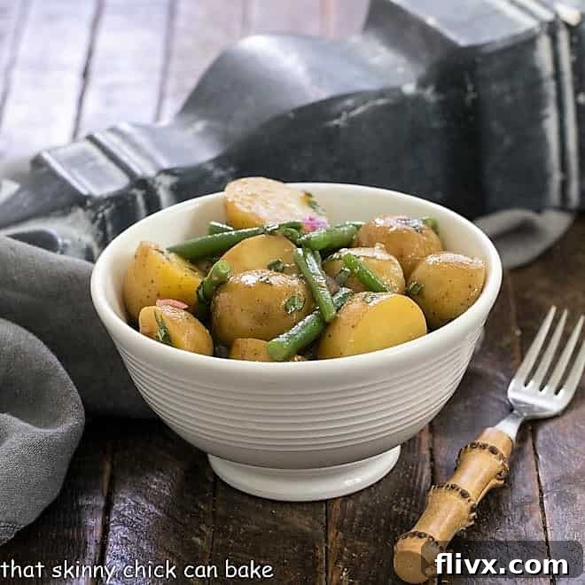 Homemade potato salad with green beans in a white bowl, representing the recipe.