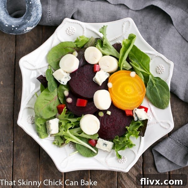 A single serving of Beet Salad with Blue Cheese and Hearts of Palm artfully arranged on a unique six-sided white salad plate.