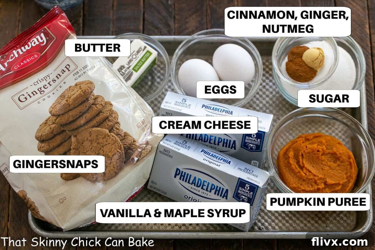 A collection of essential ingredients for pumpkin cheesecakes neatly arranged on a metal sheet pan, ready for baking.