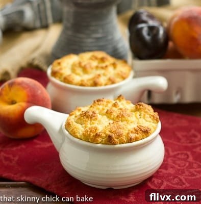 Two Peach and Plum Johnnycake Cobblers in white ceramic baking dishes