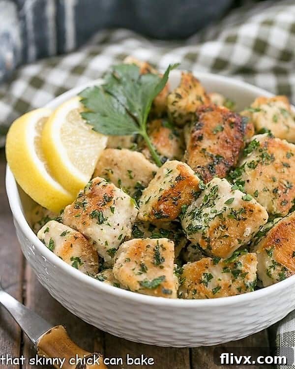 A beautifully plated dish of Pan-Fried Chicken with Garlic and Parsley in a white basket weave bowl, garnished with bright lemon wedges and a sprig of fresh parsley, signaling a fresh and flavorful meal.