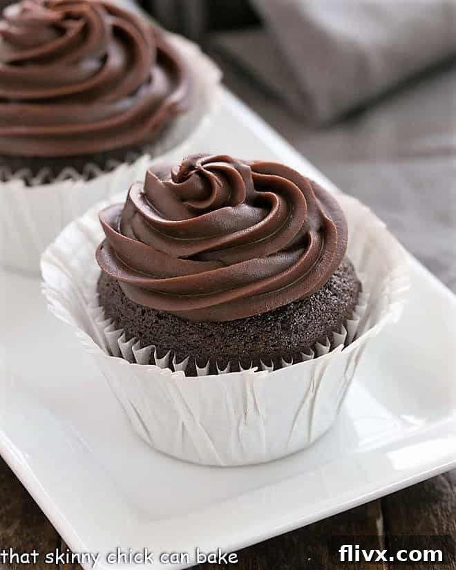 Close up of a moist blender chocolate cupcake in a white paper cup, showing its texture.
