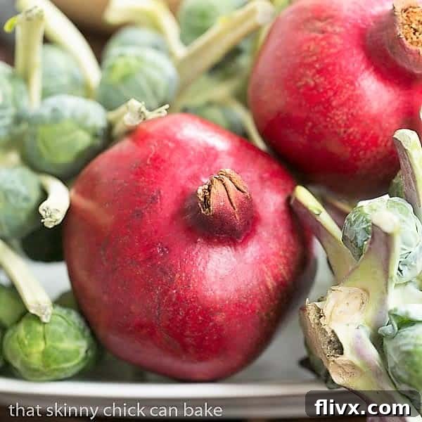 Fresh pomegranates and vibrant Brussels sprouts artfully arranged on a sheet pan, showcasing seasonal bounty.