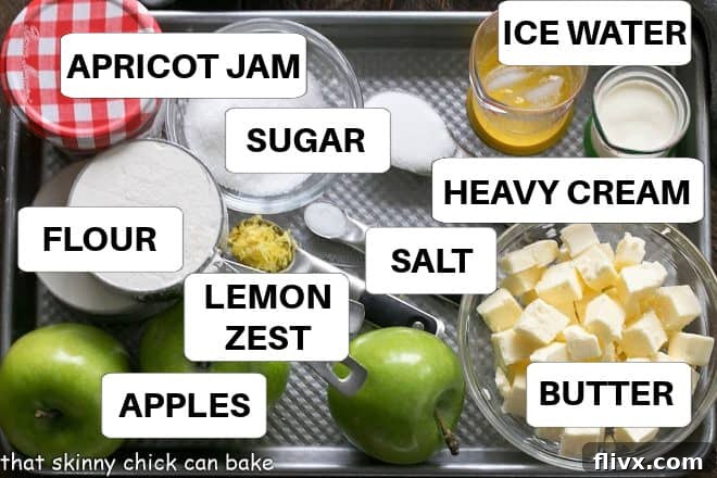 A selection of fresh ingredients for apple crostata, including apples, butter, flour, sugar, and lemon, arranged neatly on a baking sheet.