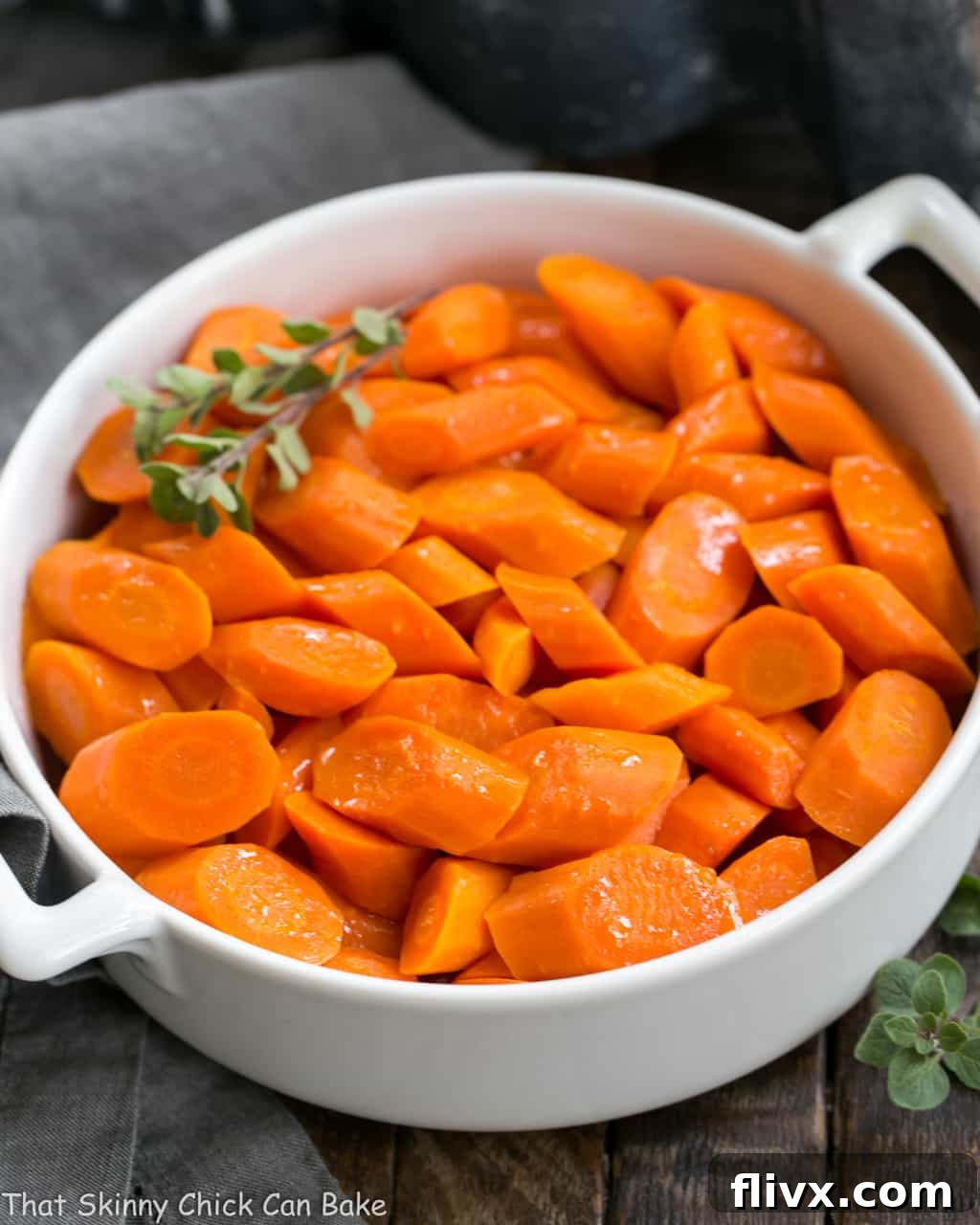 Bourbon Maple Glazed Carrots in a pristine white ceramic dish, showcasing their glossy glaze and vibrant color.