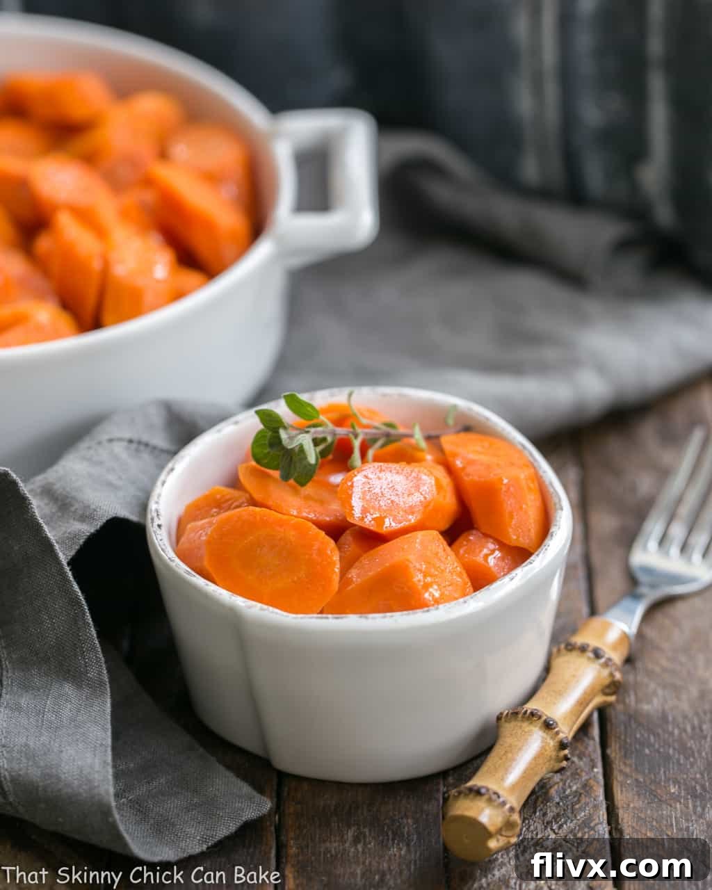 Bourbon Maple Glazed Carrots in a small white bowl with a bamboo fork, ready to be served.