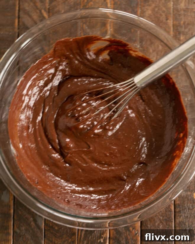 Step 3: The warm, melted chocolate and butter mixture is slowly folded into the egg and sugar mixture, ensuring a seamless blend.