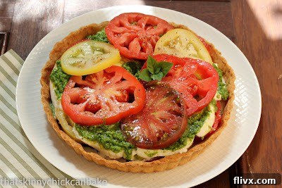 Fresh tomato tart on a white plate, close up with golden crust