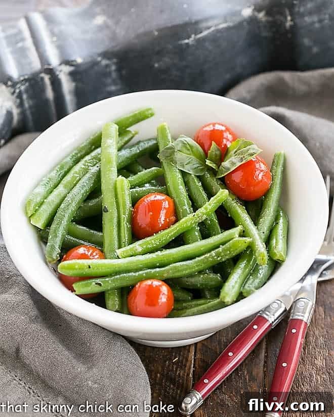 Overhead view of Italian Sauteed Green Beans in a white bowl with fresh basil.