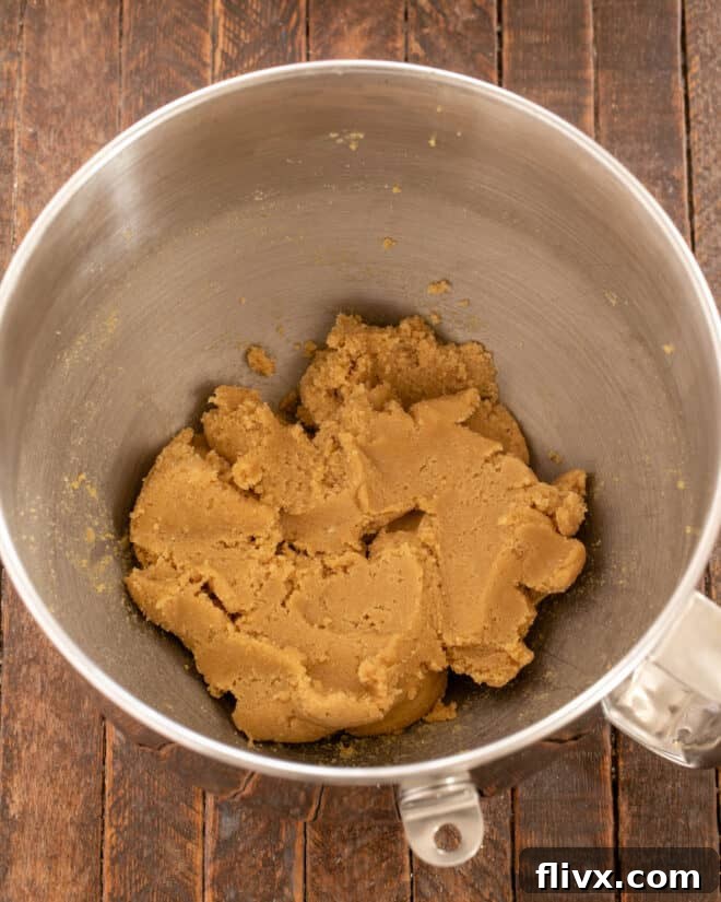 The butter, brown sugar, molasses, and granulated sugar mixture being creamed in a stand mixer until light and fluffy.