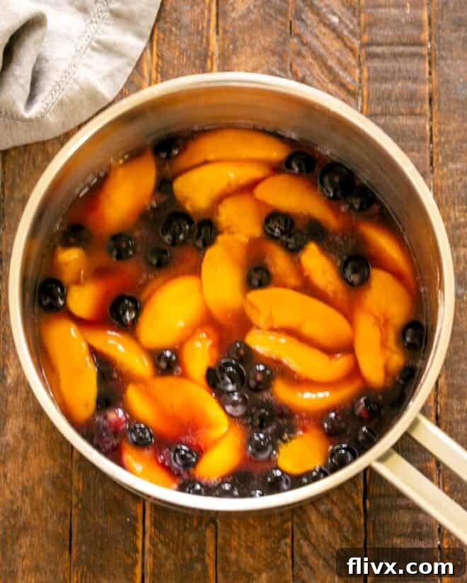 Cooking the fruit mixture until it thickens.