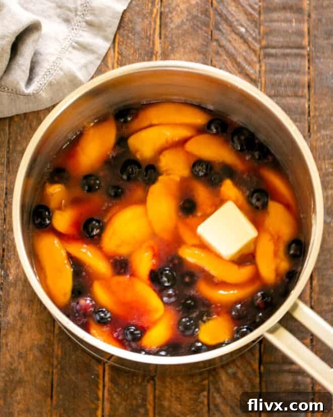 Adding butter and lemon juice to the thickened fruit mixture.