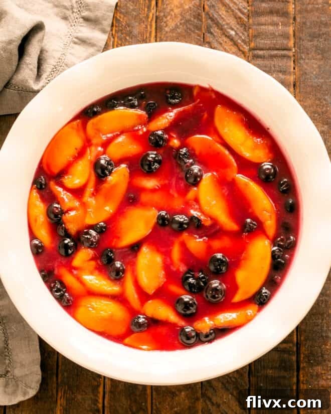 Pouring the fruit filling into an oven-safe baking dish.