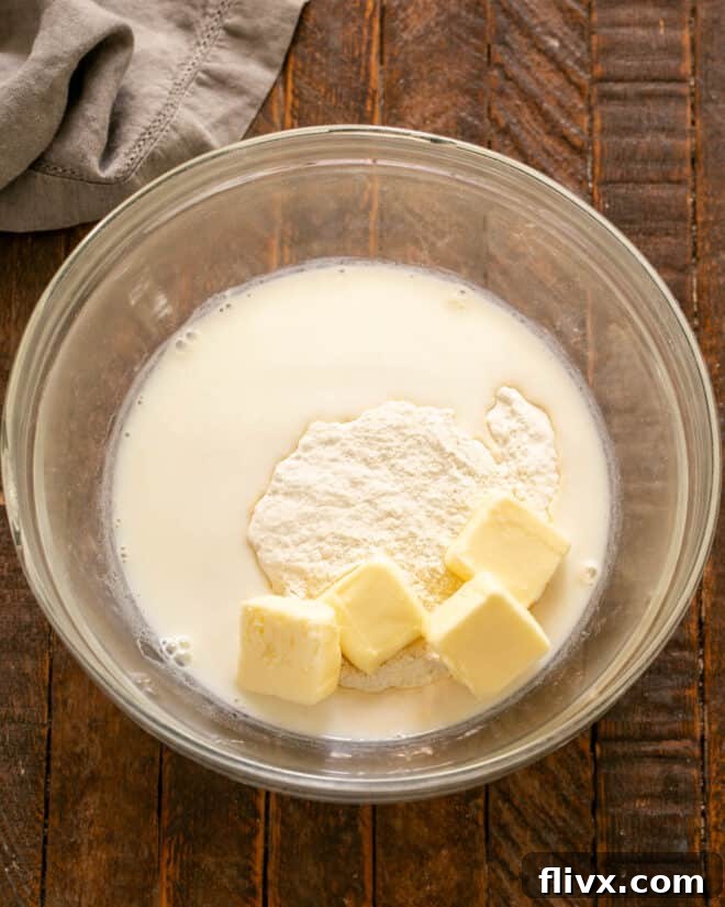 Adding milk and butter to dry ingredients and beating until smooth.