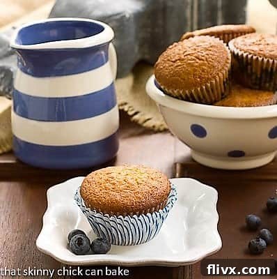 Sour Cream Blueberry Muffins - Moist, tender and full of berries! Sour Cream Blueberry Muffins in a polka dot ceramic bowl with one on a small white plate