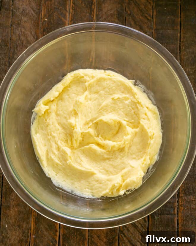 Egg added to butter and sugar in a mixing bowl.