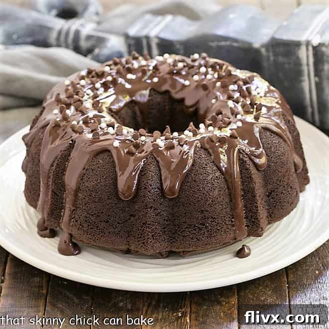 A stunning Chocolate Sour Cream Bundt Cake, beautifully glazed, presented on a white cake plate.