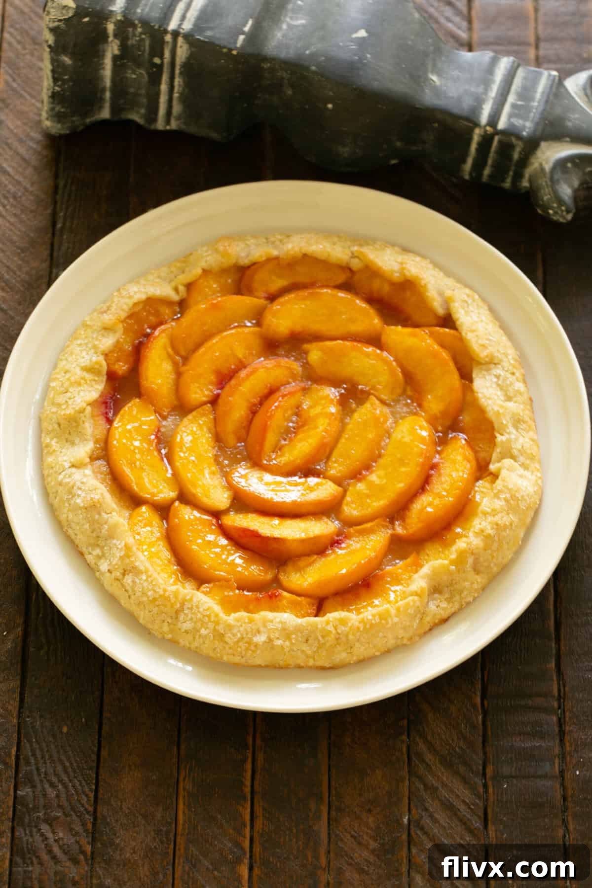 Step 7: The folded crust of the galette is brushed with an egg wash, giving it a glossy finish, and then generously sprinkled with coarse sugar for added sparkle and crunch.