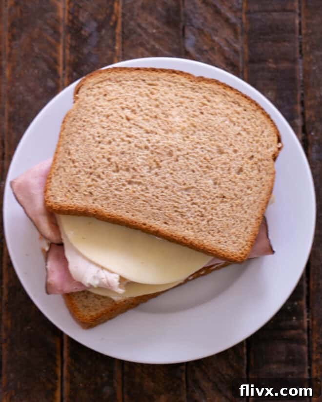 Golden Brown Sweet and Savory Monte Cristo 5 Sandwich layered with meats and cheese.