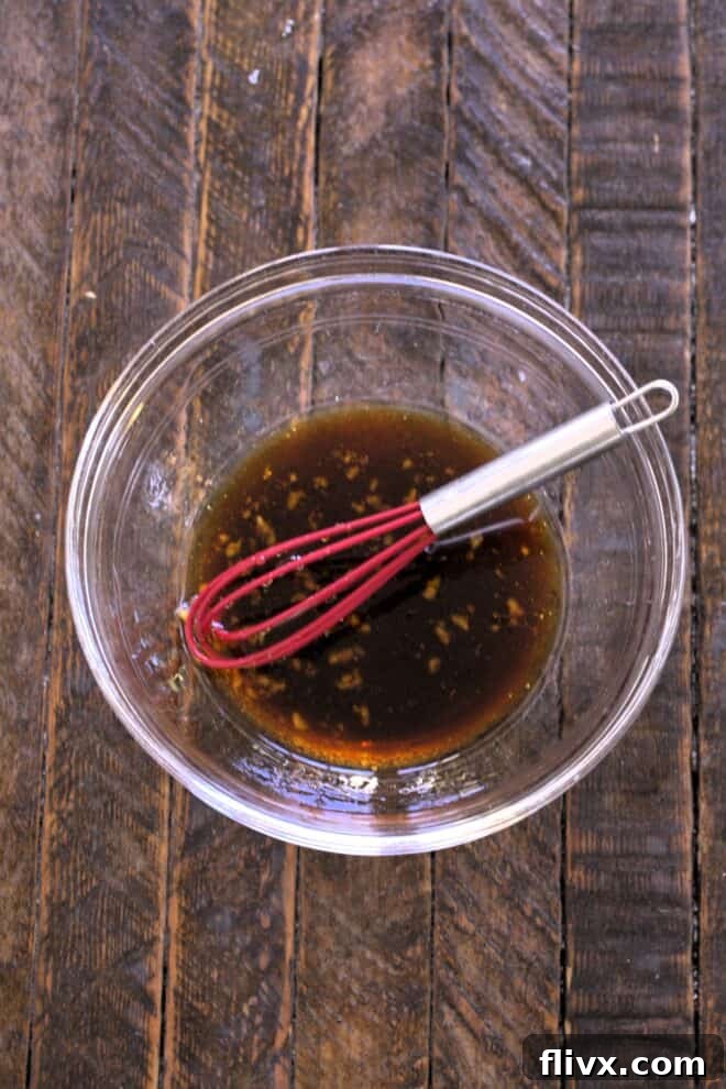 Date Night Grilled Salmon 4 Salmon marinade ingredients being whisked together in a bowl, showing the consistency and vibrant color.