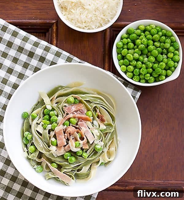 Overhead view of a generous serving of Straw and Hay Pasta in a pristine white bowl, highlighting its creamy texture and fresh ingredients.