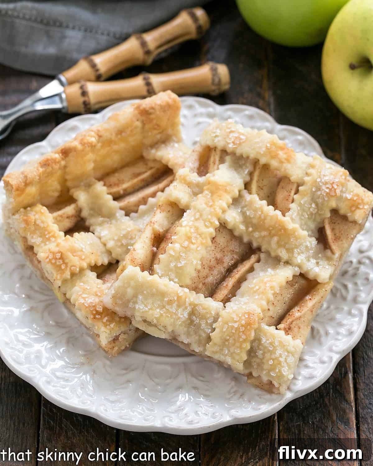 Two generous slices of Cinnamon Apple Squares, showcasing the golden lattice crust and juicy apple filling, served on a round white plate.