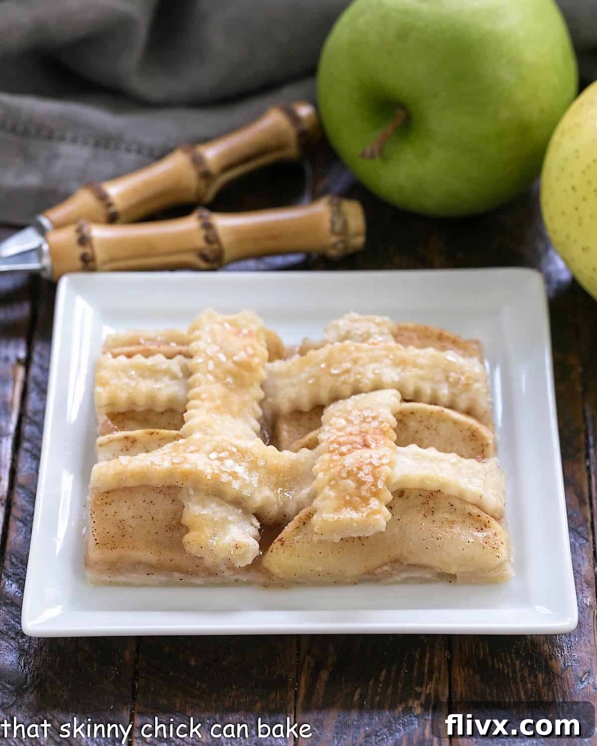 A perfectly golden slice of apple slab pie or apple squares, highlighting the tender apple filling and crisp crust, on a clean square white plate.