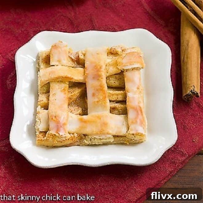 A beautifully glazed slice of apple slab pie or apple squares on a pristine white plate, showcasing the glossy topping.