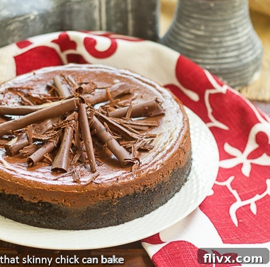 Gorgeous Double Chocolate Cheesecake on a elegant round white serving plate, garnished with chocolate curls.