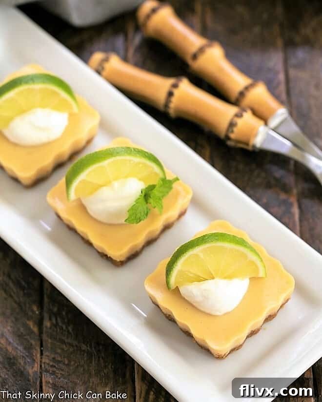 Overhead view of several Key Lime Tarts arranged neatly on a white ceramic tray, ready for serving.