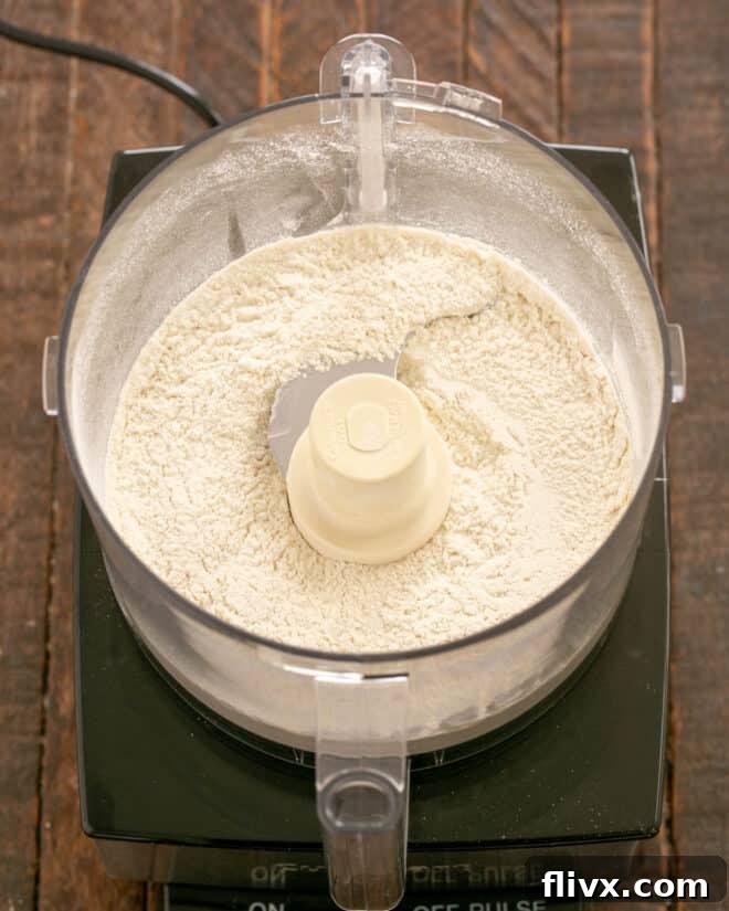 Step 1: Dry ingredients (flour, salt, sugar) are pulsed together in a food processor to combine evenly.